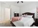 Bedroom with dark wood bed frame, pink blanket and dresser at 15175 S 185Th Ave, Goodyear, AZ 85338