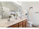 Bathroom with double sinks, a large mirror, and a toilet at 16079 W Acapulco Ln, Surprise, AZ 85379