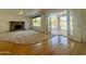 Living room with hardwood floors, fireplace, and French doors opening to a pool view at 19422 N 67Th Ln, Glendale, AZ 85308