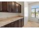 Laundry room with dark wood cabinets and tile countertops at 23907 N 83Rd Ave, Peoria, AZ 85383