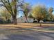 Single story home with a large front yard and mature trees at 269 Sylvan Rd, Wickenburg, AZ 85390