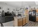 Kitchen features an island, wood cabinets, and black appliances at 13164 W Ocotillo Ln, Surprise, AZ 85374