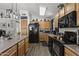 Modern kitchen with wood cabinets, black appliances, and an island at 13164 W Ocotillo Ln, Surprise, AZ 85374