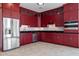 Modern kitchen with red cabinets, stainless steel appliances, and granite countertops at 40105 N 2Nd Way, Phoenix, AZ 85086