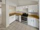 Galley kitchen with white cabinets, stainless steel appliances, and wood countertops at 14002 N 49Th Ave # 1074, Glendale, AZ 85306