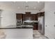 Modern kitchen with dark wood cabinets, granite island, and stainless steel appliances at 3407 E Glacier Pl, Chandler, AZ 85249