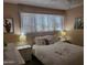 Spacious bedroom with a queen-size bed, nightstands, and window coverings at 815 N Hayden Rd # B2, Scottsdale, AZ 85257