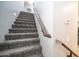 Carpeted staircase with wooden handrail leading to the upper level at 7351 W Palo Brea Ln, Peoria, AZ 85383