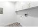 Laundry room with white cabinets and wood-look tile floor at 1236 E Mclellan Blvd, Phoenix, AZ 85014