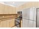 Modern kitchen with stainless steel appliances and wood cabinets at 6900 E Princess Dr # 2221, Phoenix, AZ 85054