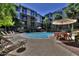 Community pool with lounge chairs, patio furniture, and palm trees at 1701 E Colter St # 291, Phoenix, AZ 85016