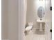 Modern bathroom with pedestal sink, toilet and oval mirror at 10611 E Tumbleweed Ave, Mesa, AZ 85212