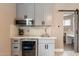Modern wet bar with gray cabinets, quartz countertop, and wine fridge at 8608 E Angus Dr, Scottsdale, AZ 85251