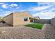 Tan house exterior with artificial turf backyard at 21451 W Palm Ln, Buckeye, AZ 85396