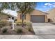 Tan house with 2 car garage and landscaped front yard at 21451 W Palm Ln, Buckeye, AZ 85396