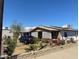 Ranch-style home with landscaped yard, driveway, and mature plants at 303 N 7Th St, Avondale, AZ 85323
