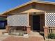 Brick home with a covered porch, lattice accents, and a well-maintained front yard at 303 N 7Th St, Avondale, AZ 85323