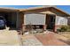Brick ranch home with covered porch, lattice accents, and well-maintained landscaping at 303 N 7Th St, Avondale, AZ 85323