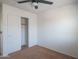 Bedroom with ceiling fan, closet, and neutral carpeting at 25796 W Hazel Dr, Buckeye, AZ 85326