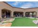 Landscaped backyard oasis with artificial turf, flagstone pathway, and covered patio at 35140 N 52Nd Pl, Cave Creek, AZ 85331