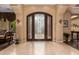 Elegant entryway with a large, ornate iron-detailed door and light-colored flooring at 35140 N 52Nd Pl, Cave Creek, AZ 85331