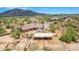 Aerial view of a large property with a house, stables and mountain views at 35140 N 52Nd Pl, Cave Creek, AZ 85331