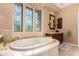 Spa-like bathroom with a large soaking tub and stained glass windows at 35140 N 52Nd Pl, Cave Creek, AZ 85331