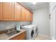 Bright laundry room with washer, dryer, cabinets, and a sink at 5116 W Trotter Trl, Phoenix, AZ 85083