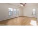 Bright bedroom with wood-look tile floors and multiple windows at 19741 E Reins Rd, Queen Creek, AZ 85142