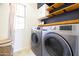 Laundry room with washer, dryer, and built-in shelving at 17555 W Dalea Dr, Goodyear, AZ 85338