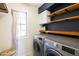Bright laundry room with washer, dryer, and additional storage at 17555 W Dalea Dr, Goodyear, AZ 85338