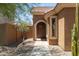 Inviting entryway with a dark brown door and desert plants at 17555 W Dalea Dr, Goodyear, AZ 85338