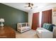 Bedroom with crib, armchair, and wood dresser at 17555 W Dalea Dr, Goodyear, AZ 85338