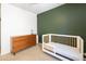 Bedroom with crib, dresser, and green accent wall at 17555 W Dalea Dr, Goodyear, AZ 85338