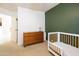 Bedroom with crib, dresser, and access to hallway at 17555 W Dalea Dr, Goodyear, AZ 85338