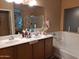Double vanity bathroom with a large soaking tub at 44973 W Sandhill Rd, Maricopa, AZ 85139