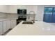 Modern kitchen features a large island with a stainless steel sink and faucet at 46137 W Starlight Dr, Maricopa, AZ 85139