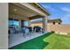 Covered patio with seating area, grill, and artificial turf at 32269 N 133Rd Dr, Peoria, AZ 85383