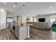 Open kitchen with island, stainless steel appliances, and wood floors at 32269 N 133Rd Dr, Peoria, AZ 85383