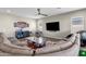 Open living area featuring sectional sofa and large TV at 32269 N 133Rd Dr, Peoria, AZ 85383