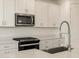 Modern kitchen with white cabinets and stainless steel appliances at 37375 W Patterson St, Maricopa, AZ 85138