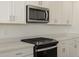 Modern kitchen with white cabinets and stainless steel appliances at 37375 W Patterson St, Maricopa, AZ 85138