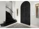 Grand entryway with a striking black metal door and staircase at 19452 N 98Th Pl, Scottsdale, AZ 85255