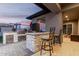 Outdoor kitchen with built-in grill, bar seating, and adjacent play area at 12 E Quartz Rock Rd, Phoenix, AZ 85085