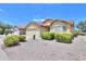 House exterior, showcasing tan facade and nicely landscaped front yard at 2380 E Seville E Ct, Casa Grande, AZ 85194