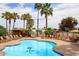 Refreshing community pool surrounded by palm trees and lounge chairs at 11596 W Sierra Dawn Blvd # 196, Surprise, AZ 85378