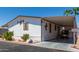 Single-wide mobile home with carport and desert landscaping at 11596 W Sierra Dawn Blvd # 196, Surprise, AZ 85378