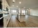 Modern kitchen with white cabinets, island, stainless steel appliances, and wood-style flooring at 22886 E Alyssa Rd, Queen Creek, AZ 85142