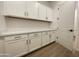 Laundry room with white cabinets, countertops, and wood-look tile flooring at 22886 E Alyssa Rd, Queen Creek, AZ 85142