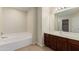 Clean bathroom with double vanity, bathtub, and a large mirror at 33025 N Mildred Ln, San Tan Valley, AZ 85144